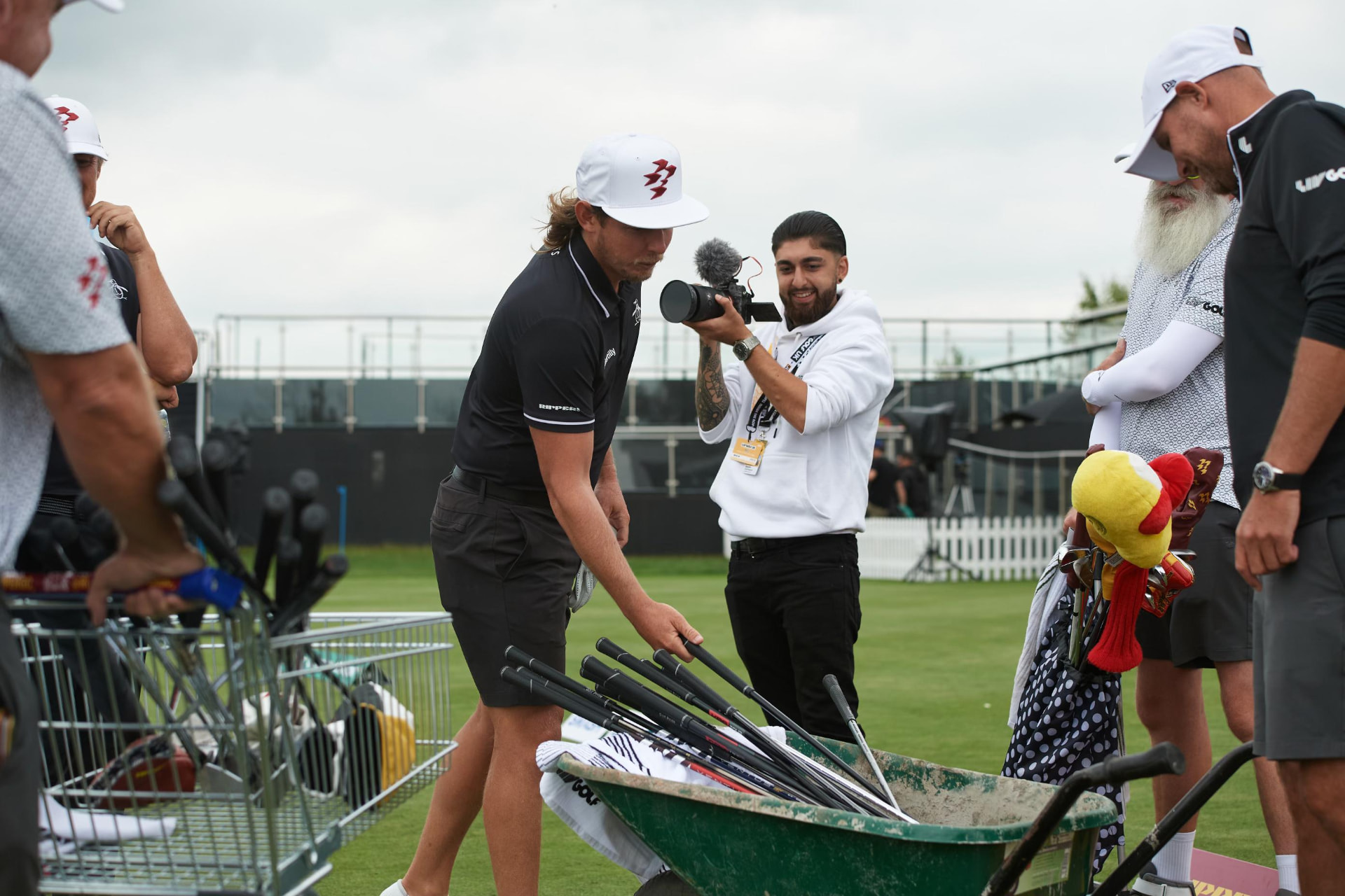I Hate Digital videographer filming a player selecting clubs on the range at a LIV Golf event